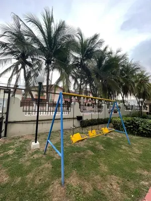 a playground with yellow and blue swings and palm trees at Apartamento en el Norte a 5 Minutos de Buenavista in Barranquilla