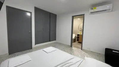 a bedroom with a white bed and a mirror at Apartamento en el Norte a 5 Minutos de Buenavista in Barranquilla