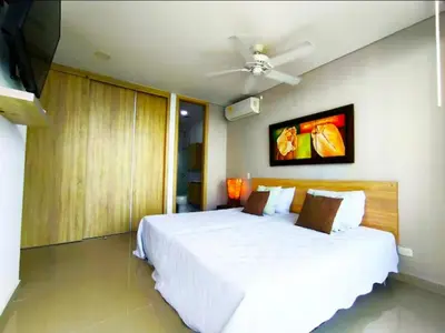 a bedroom with a white bed and a ceiling fan at Incredible apartment in Cartagena a few meters from the Sea in Cartagena de Indias