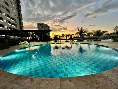 a large blue swimming pool with a sunset in the background at Loft cerca a la playa en Santa Marta Wi-Fi- Santa Marina in Santa Marta