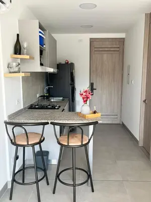 a kitchen with two bar stools and a counter top at Loft cerca a la playa en Santa Marta Wi-Fi- Santa Marina in Santa Marta