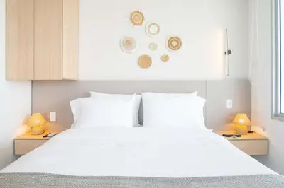 a bedroom with a large white bed with two lamps at Elegant Beachview 1BR with Balcony in Crespo in Cartagena de Indias