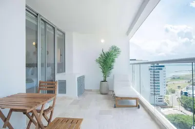a dining room with a table and chairs and a large window at Elegant Beachview 1BR with Balcony in Crespo in Cartagena de Indias