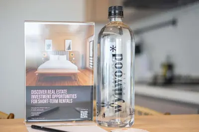 a bottle of water sitting on a table next to a book at Elegant Beachview 1BR with Balcony in Crespo in Cartagena de Indias