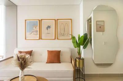 a living room with a white couch and a mirror at Elegant Beachview 1BR with Balcony in Crespo in Cartagena de Indias