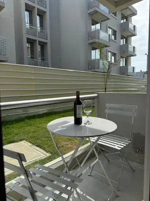 a white table with a bottle of wine and two chairs at A pasos de playa privada Serena del Mar Cartagena in Cartagena de Indias