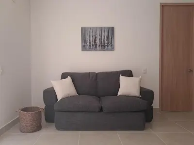 a couch with two pillows sitting in a living room at A pasos de playa privada Serena del Mar Cartagena in Cartagena de Indias