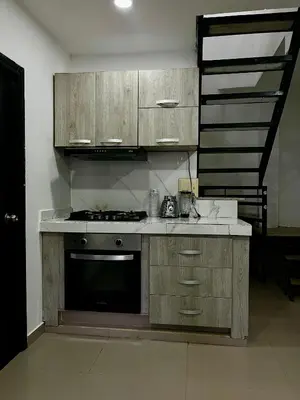 a kitchen with wooden cabinets and a stove at Apartamento DUPLEX para Grupos 9 pax in Cartagena de Indias