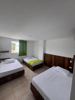 a bedroom with two beds and a window at Hotel Palma Grande By Origen