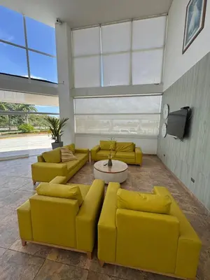 a living room with yellow couches and a tv at Hotel Palma Grande By Origen