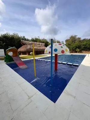 a pool with a playground with an umbrella and a swimming pool at Hotel Palma Grande By Origen