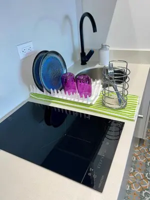 a kitchen sink with purple dishes on a shelf at Lovely Suite steps away from the airport and beach in Cartagena de Indias