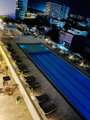 a swimming pool on top of a building with chairs at Lovely Suite steps away from the airport and beach in Cartagena de Indias
