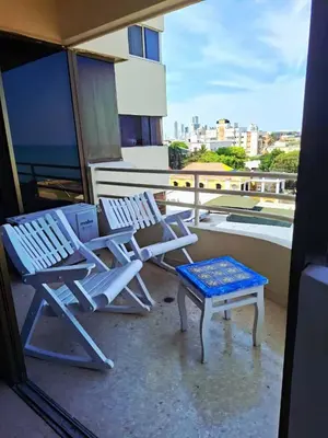 two chairs and a stool sitting on a balcony at Relajación y vista al mar en hermoso apartamento en Cartagena in Cartagena de Indias