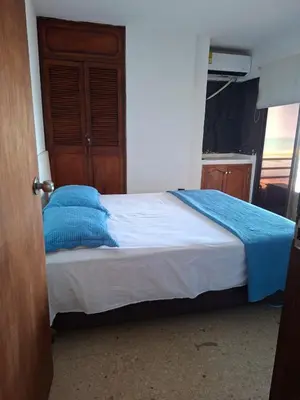 a bedroom with a bed with blue pillows on it at Relajación y vista al mar en hermoso apartamento en Cartagena in Cartagena de Indias