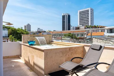 a patio with a bench and a fountain on a roof at Luxury House in the heart of Cartagena with Jacuzzi in Cartagena de Indias
