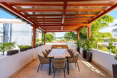 an outdoor patio with a wooden table and chairs at Luxury House in the heart of Cartagena with Jacuzzi in Cartagena de Indias