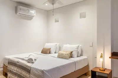 a white bedroom with a bed with white sheets and pillows at Luxury House in the heart of Cartagena with Jacuzzi in Cartagena de Indias