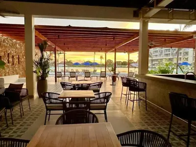 a restaurant with tables and chairs with a view of the ocean at Apartamentos Baia Kristal - Escapada a Cartagena in Cartagena de Indias