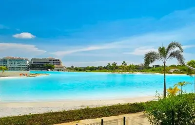 a view of a beach with blue water and palm trees at Apartamentos Baia Kristal - Escapada a Cartagena in Cartagena de Indias