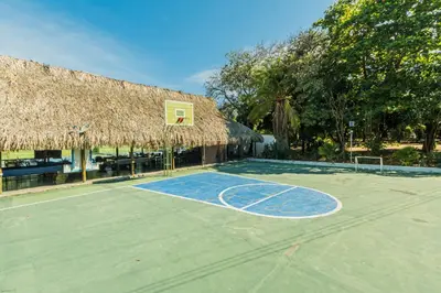 a basketball court with a thatched roof at Paraíso By Elemnt Rentals in Santa Marta