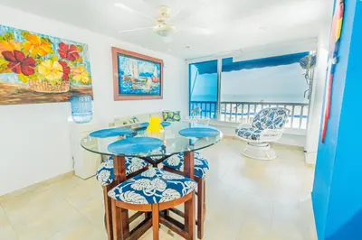a dining room with a glass table and chairs at Paraíso By Elemnt Rentals in Santa Marta