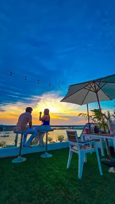 two people sitting at a picnic table with the sunset at Hotel Capsula CAPS Cartagena in Cartagena de Indias