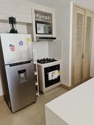 a kitchen with a refrigerator and a stove and a microwave at Apt 2 rooms with private beach and ideal pool in Cartagena de Indias