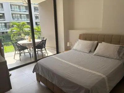 a bedroom with a bed and a balcony with a table at Apt 2 rooms with private beach and ideal pool in Cartagena de Indias