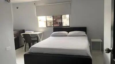 a bedroom with a bed and a table and a desk at Hotel Tres Estrellas Fundacion in Fundación