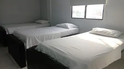 three beds in a room with a window at Hotel Tres Estrellas Fundacion in Fundación