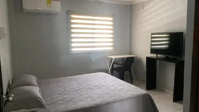 a bedroom with a bed and a television and a table at Hotel Tres Estrellas Fundacion in Fundación