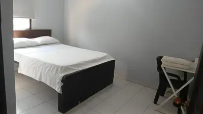 a bedroom with a bed with a chair and a table at Hotel Tres Estrellas Fundacion in Fundación