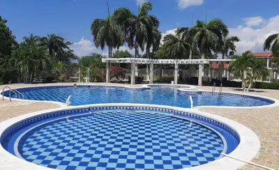 a large swimming pool with blue tiles on the ground at San ANTERO Cabaña Positano in San Antero