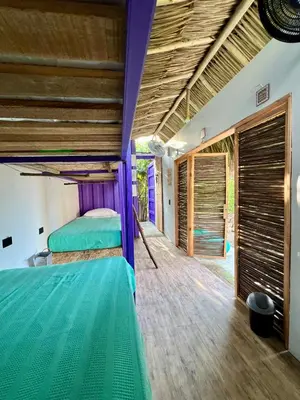 a bedroom with a bed and a wooden floor at Riders Shared Room en Mojarra Beach in Salina de Rey