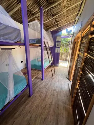 a room with two bunk beds and a wooden floor at Riders Shared Room en Mojarra Beach in Salina de Rey