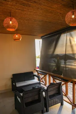 a living room with a large screen and chairs at Mero Beach - Apartamento frente al mar en Tolú in San Silvestre