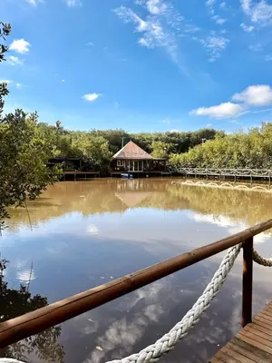 a bridge over a body of water with a house at Mero Beach - Apartamento frente al mar en Tolú in San Silvestre
