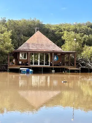 a house sitting on top of a body of water at Mero Beach - Apartamento frente al mar en Tolú in San Silvestre