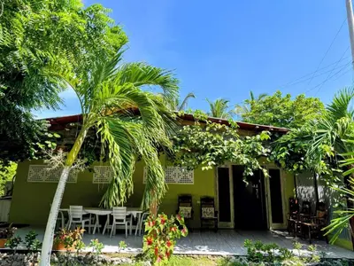 a green house with a table and chairs in front of it at Suemar Cabaña de Playa en Isla de Tierra Bomba in Cartagena de Indias
