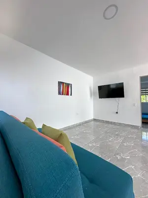 a living room with a blue couch and a flat screen tv at Casa2 Duplex AC WiFi Piscina Acceso al mar in San Bernardo del Viento