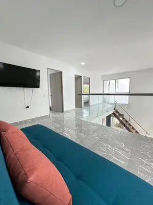 a living room with a blue couch and a television at Casa2 Duplex AC WiFi Piscina Acceso al mar in San Bernardo del Viento