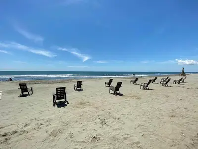a group of chairs sitting on a beach at Casa2 Duplex AC WiFi Piscina Acceso al mar in San Bernardo del Viento