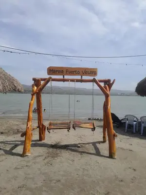 a swing on a beach with the ocean in the background at Marina Puerto Velero Cabaña in Tubará