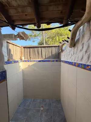 a bathroom with white tiled walls and a wooden ceiling at Cabaña 8 personas frente al mar con deck privado in Moñitos