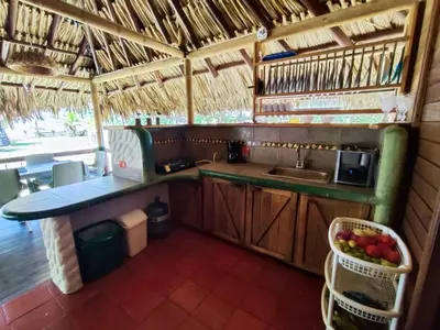 a kitchen with a sink and a counter with a basket of fruit at Cabaña 8 personas frente al mar con deck privado in Moñitos