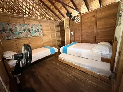 a room with two beds and a camera in it at Cabaña 8 personas frente al mar con deck privado in Moñitos