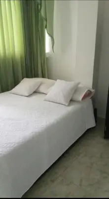 a bed with white sheets and pillows in a bedroom at Piezas en arriendo Barranquilla in Barranquilla