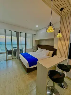 a bedroom with a bed and a desk and chairs at Cartagena Beach exclusive & Resort in Cartagena de Indias