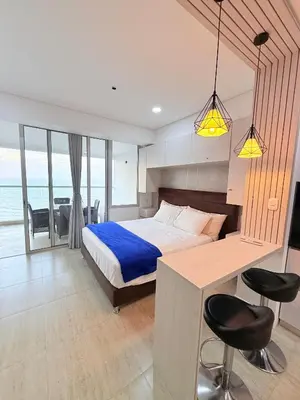 a bedroom with a bed and a desk and chairs at Cartagena Beach exclusive & Resort in Cartagena de Indias